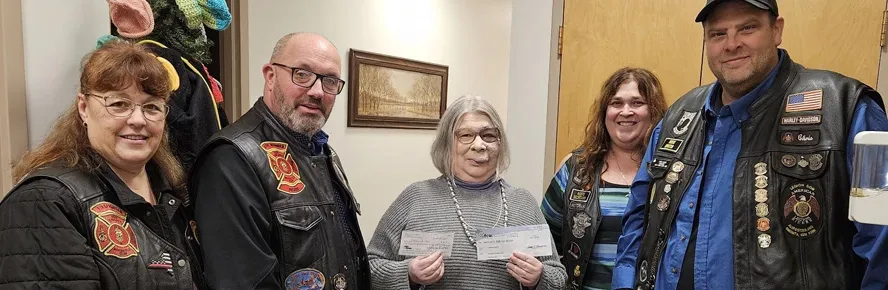 ALR Post 259 and Red Knights 44 members presenting boot drive checks to a Catholic Charities representative