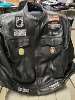Front of a black American Legion Riders vest with name, affiliation, and service patches