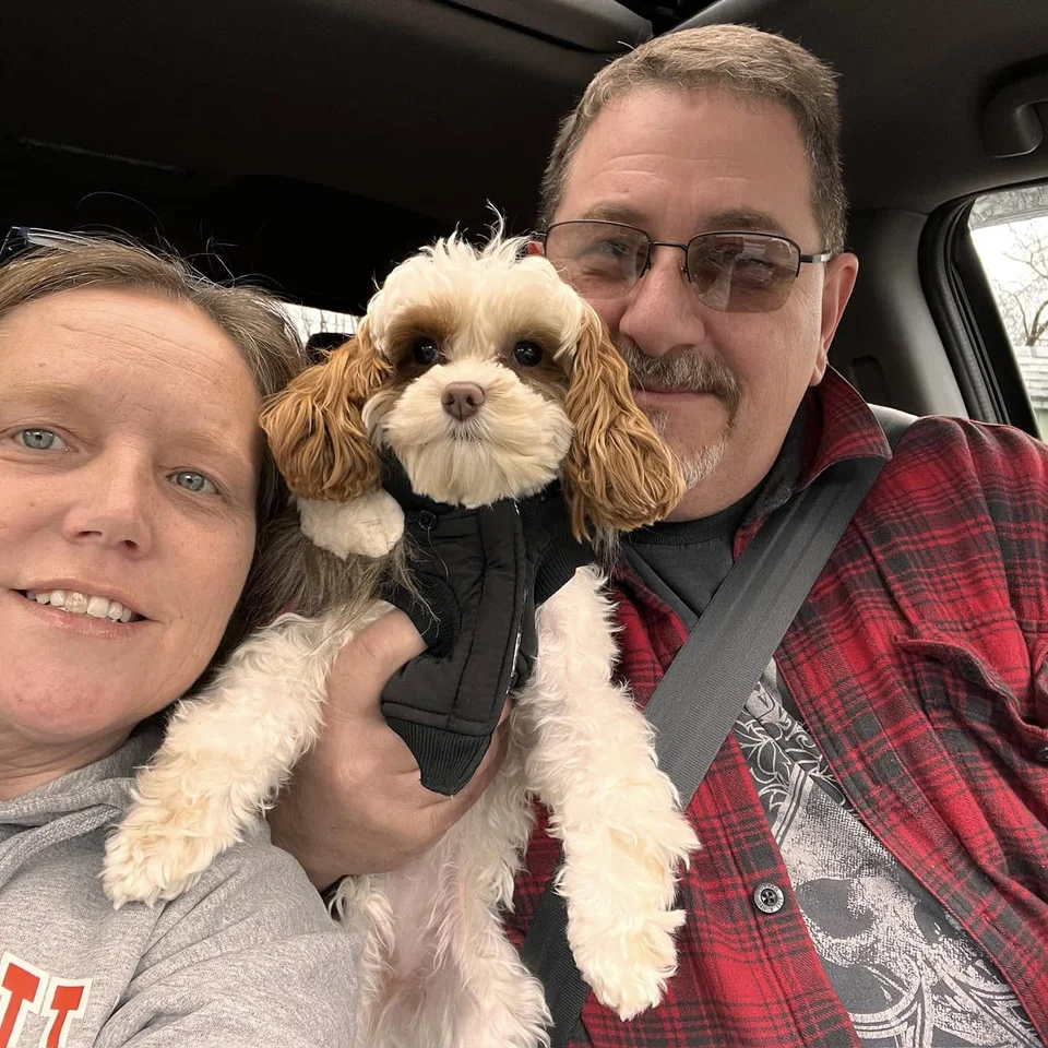 Deb and Chris Dennis taking a car selfie with Bailey between them