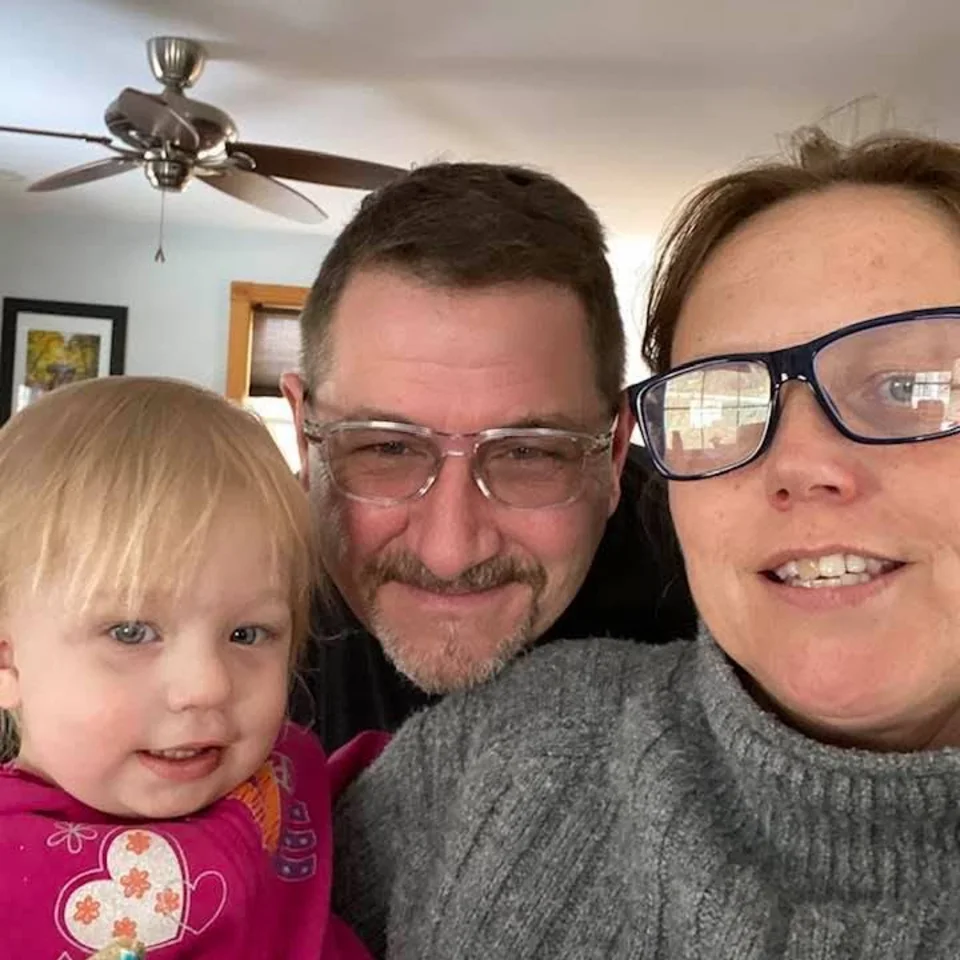 Chris and Deb Dennis taking a selfie with a young child