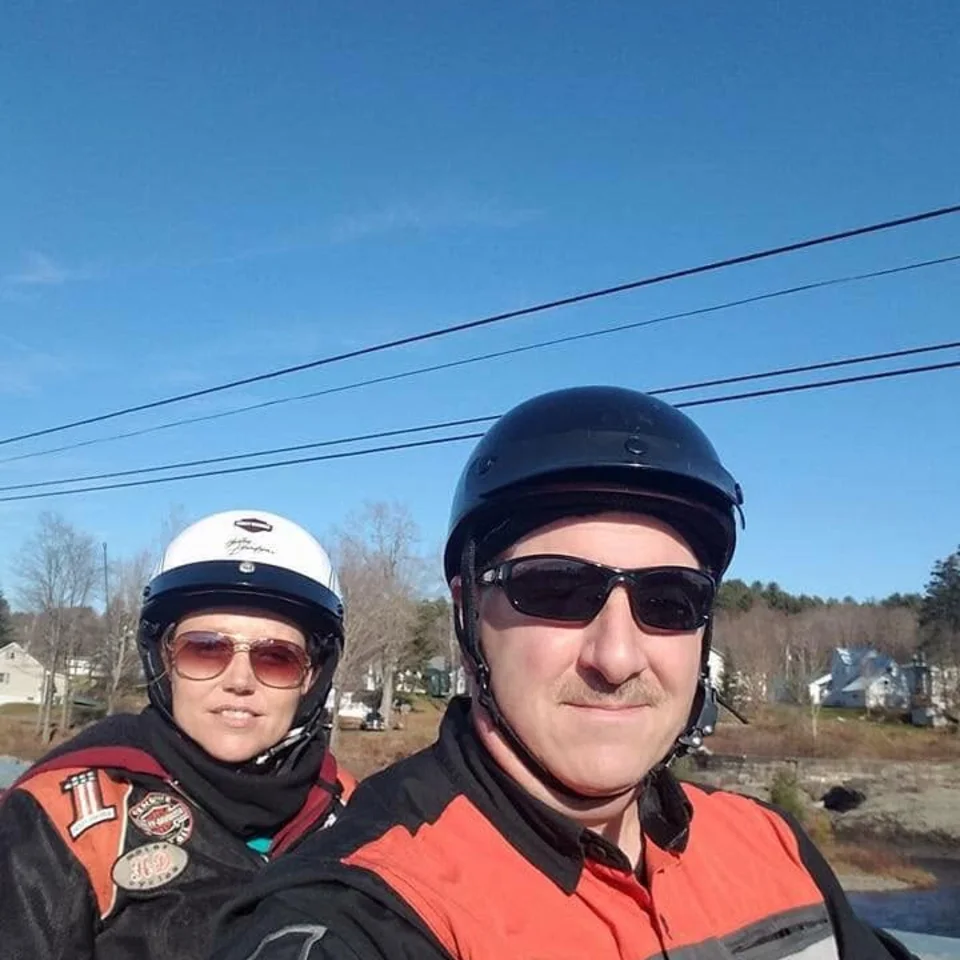 Chris and Deb Dennis wearing riding gear and helmets outdoors