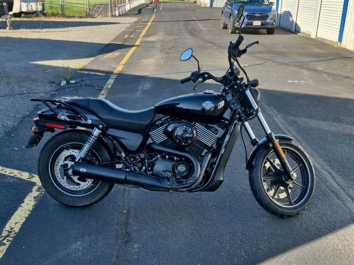 Connor Ouimet’s black Harley-Davidson Street 750 parked on the pavement outside a row of storage units