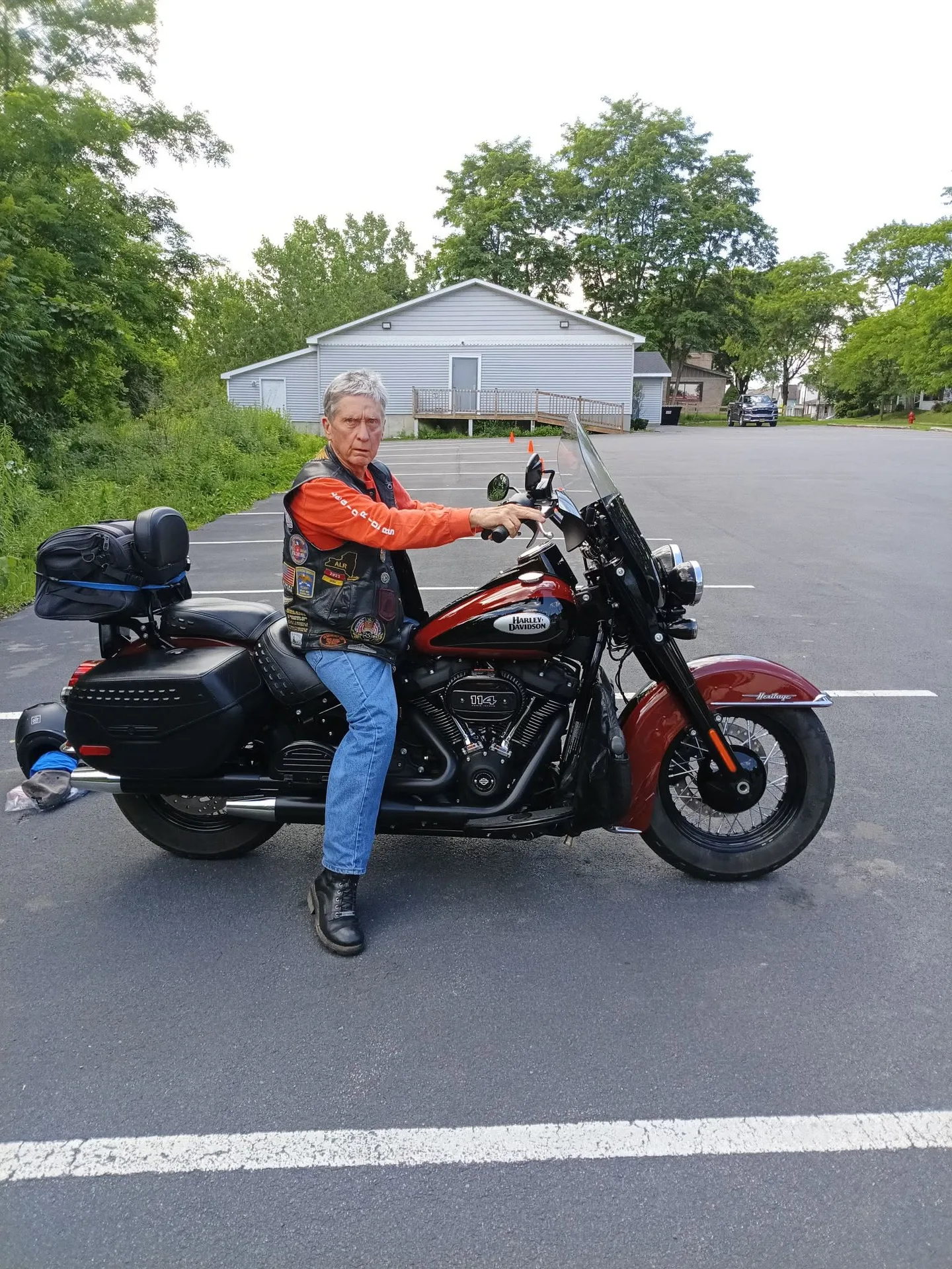 David Buck sitting on his red and black 2024 Harley-Davidson Heritage