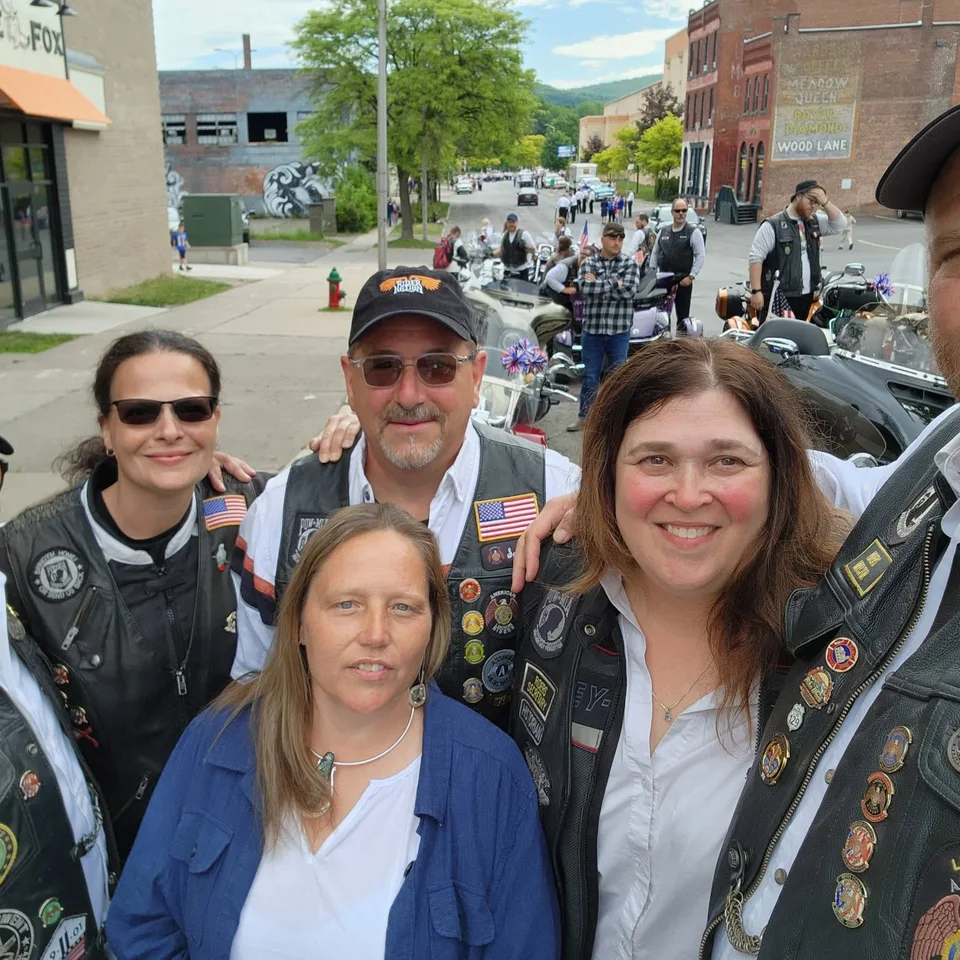 Deb Dennis taking a group selfie with fellow riders at an outdoor event
