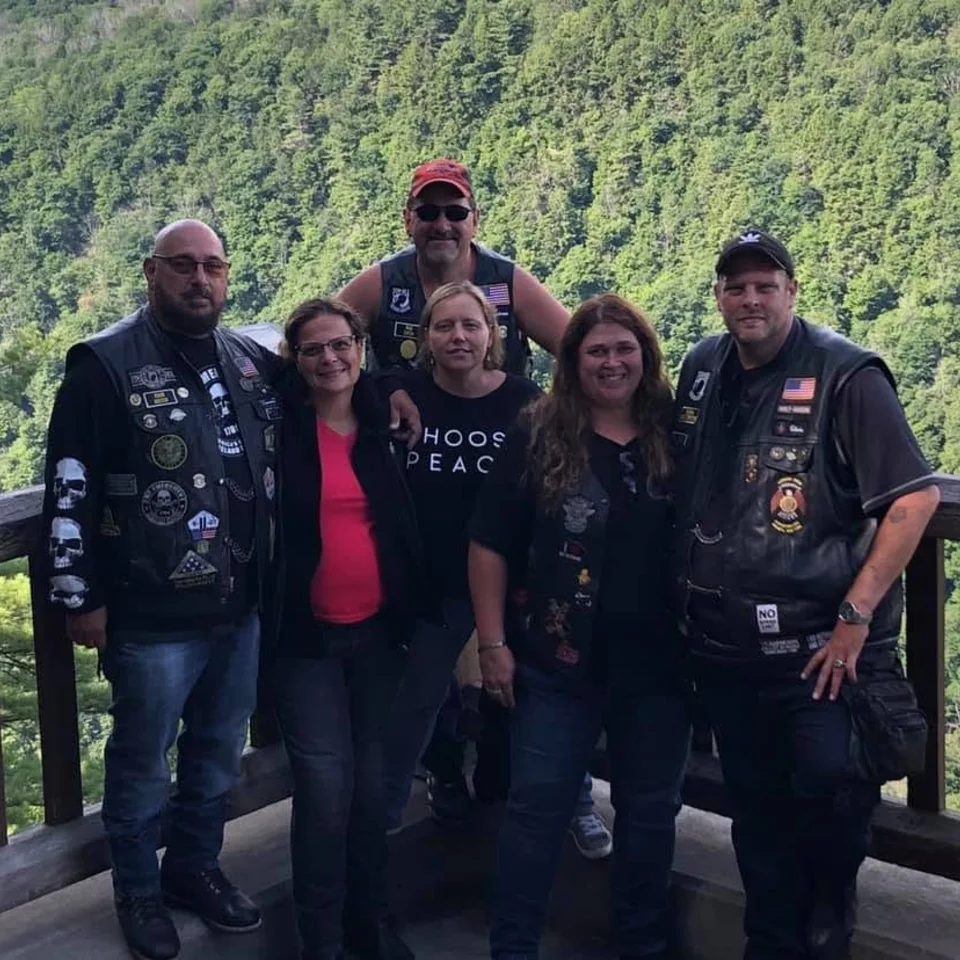 Deb and Chris Dennis with friends at a wooded scenic overlook