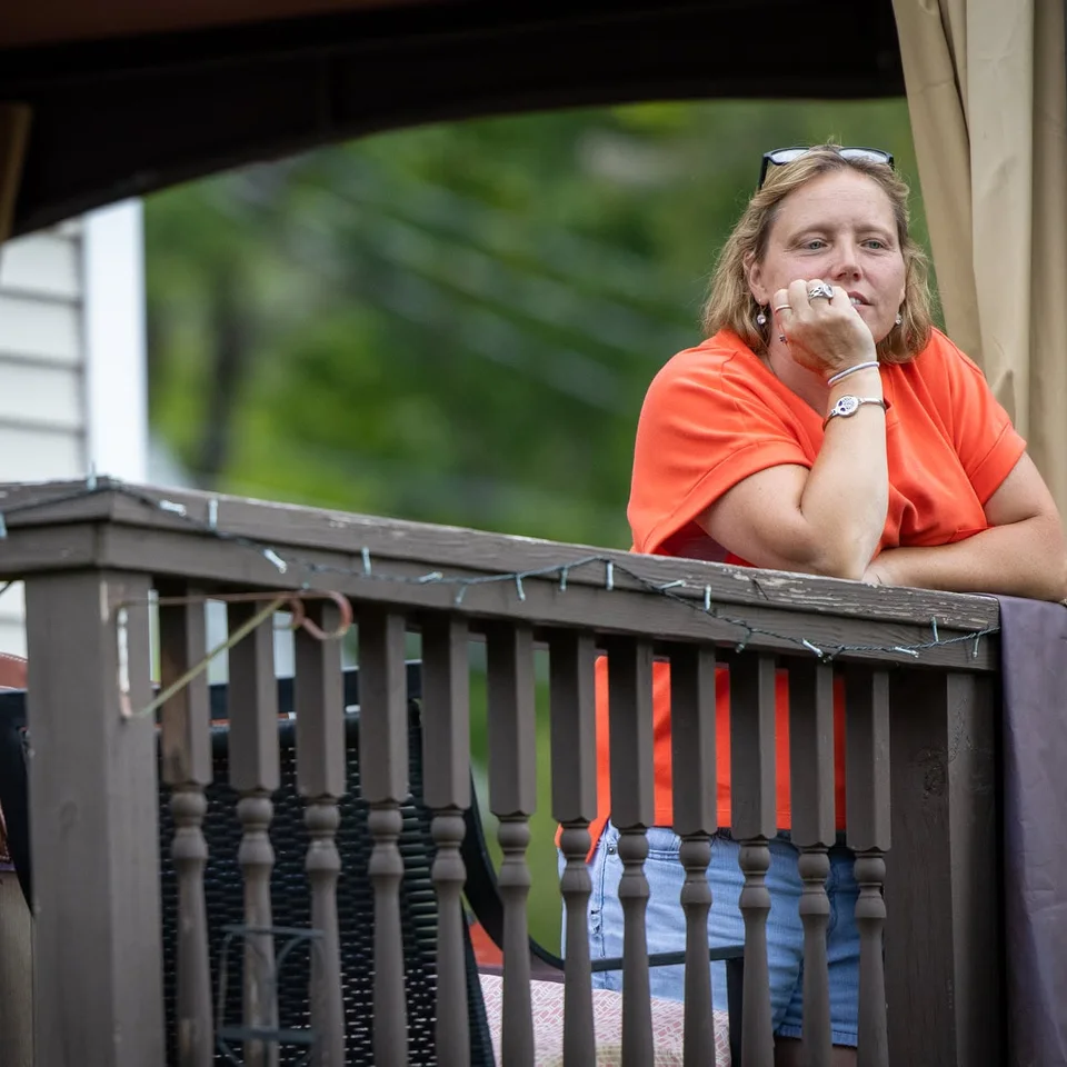 Deb Dennis leaning on a deck railing outdoors