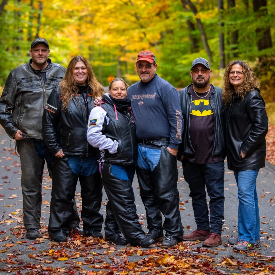 Deb and Chris Dennis with friends on a wooded road in autumn