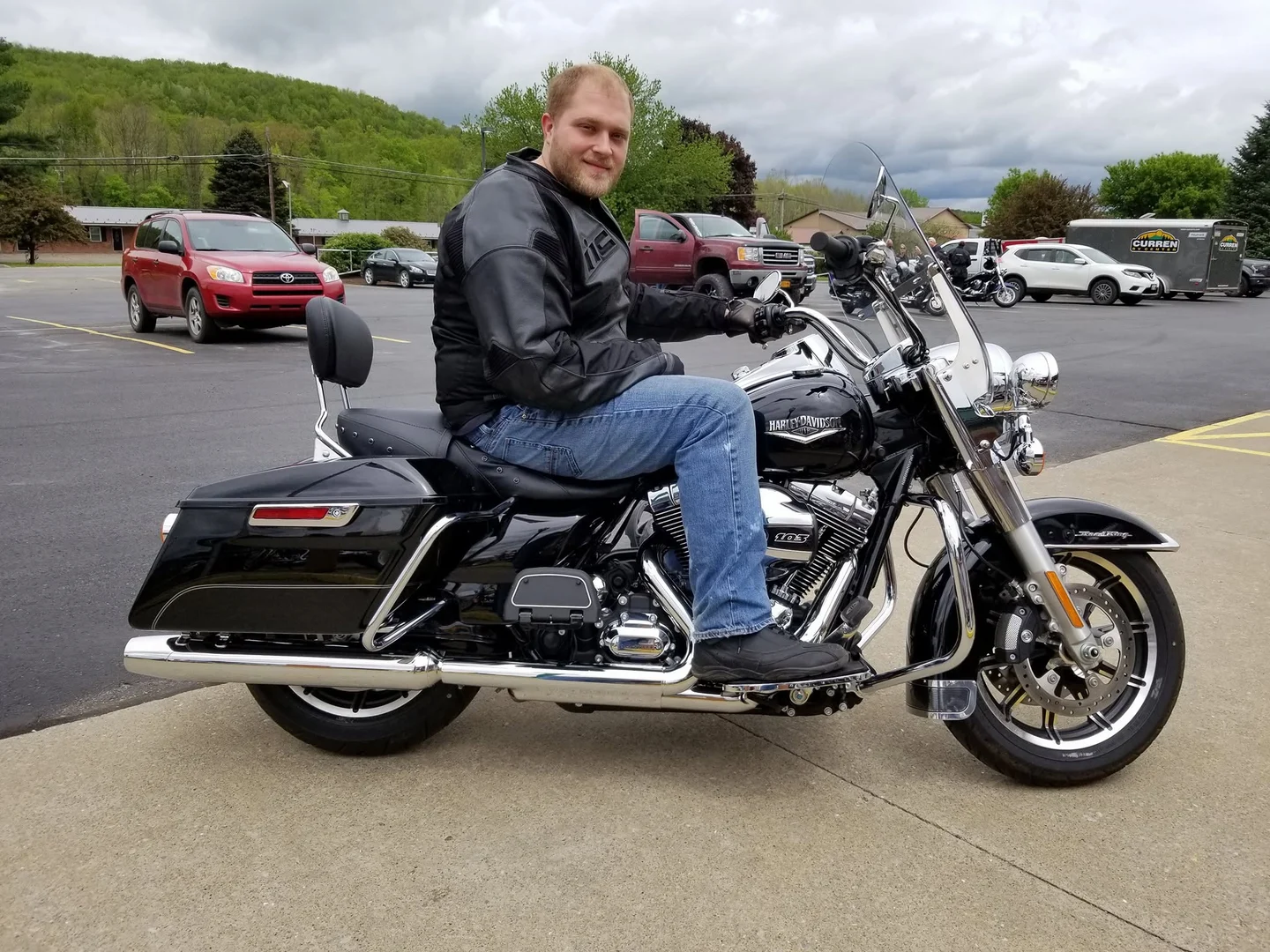 Devin Chase sitting on his black 2016 Harley-Davidson Road King