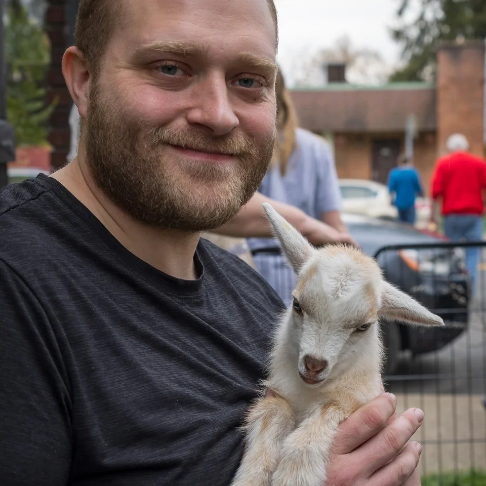 Devin Chase smiling while holding a small dog