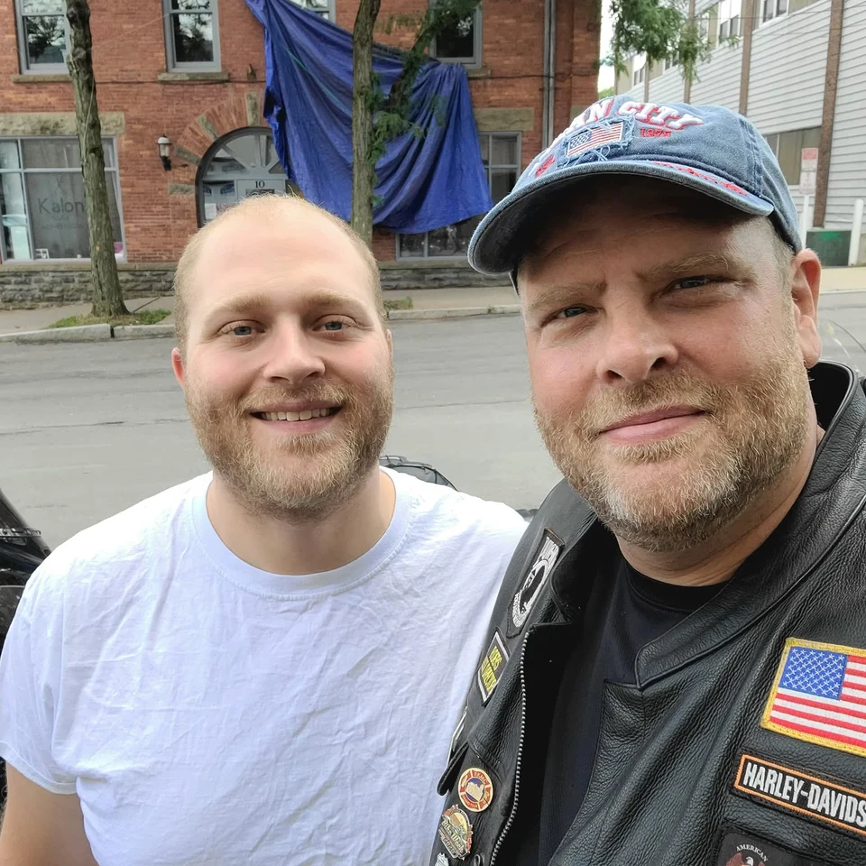 Devin Chase taking an outdoor selfie with another Rider