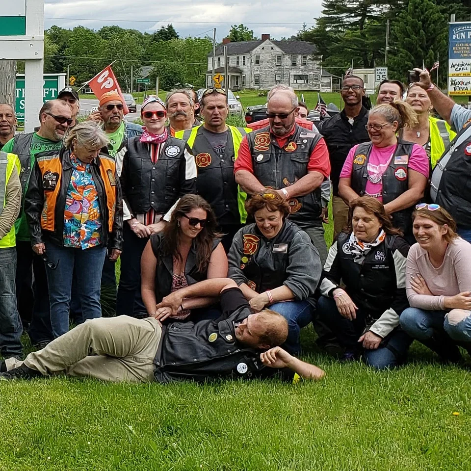 Devin Chase with a large group of Riders gathered outside a building