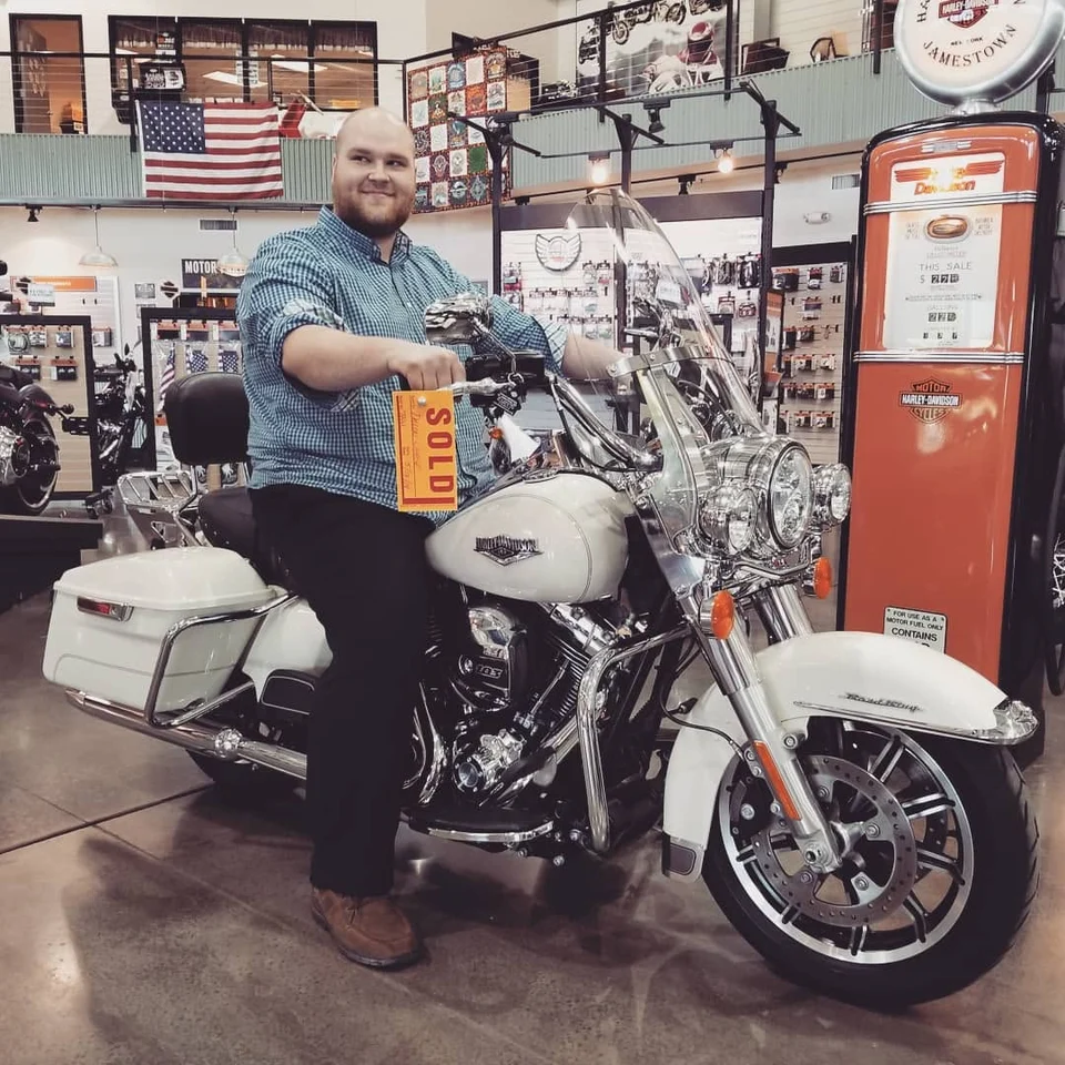 Dillon Chase sitting on his White Gold Harley-Davidson Road King at the dealership