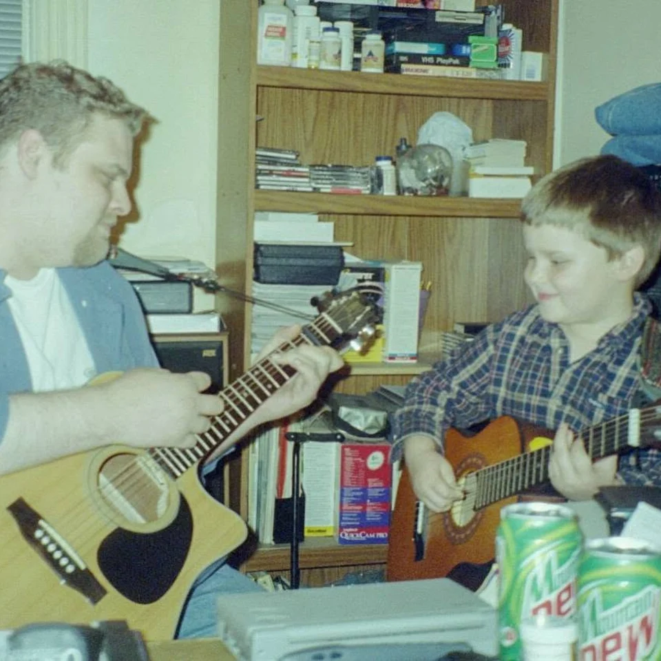 Dillon Chase as a child playing guitar with an adult
