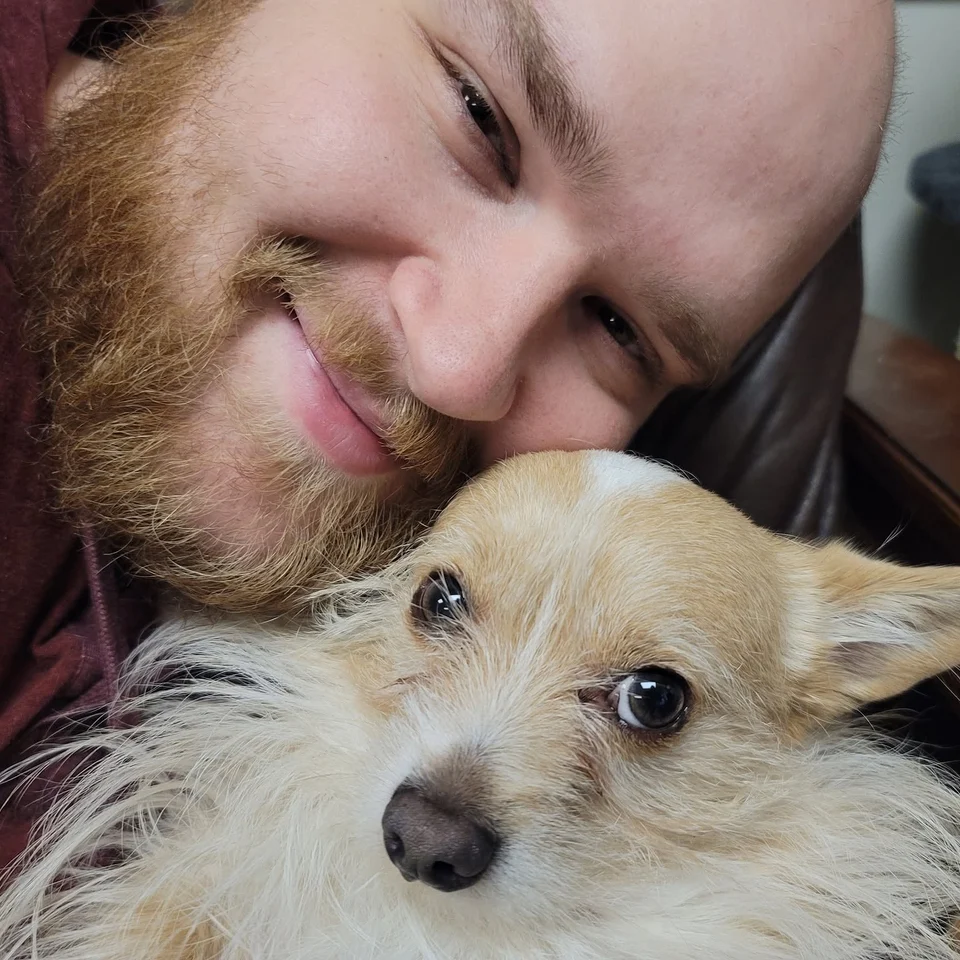 Dillon Chase cuddling a small dog