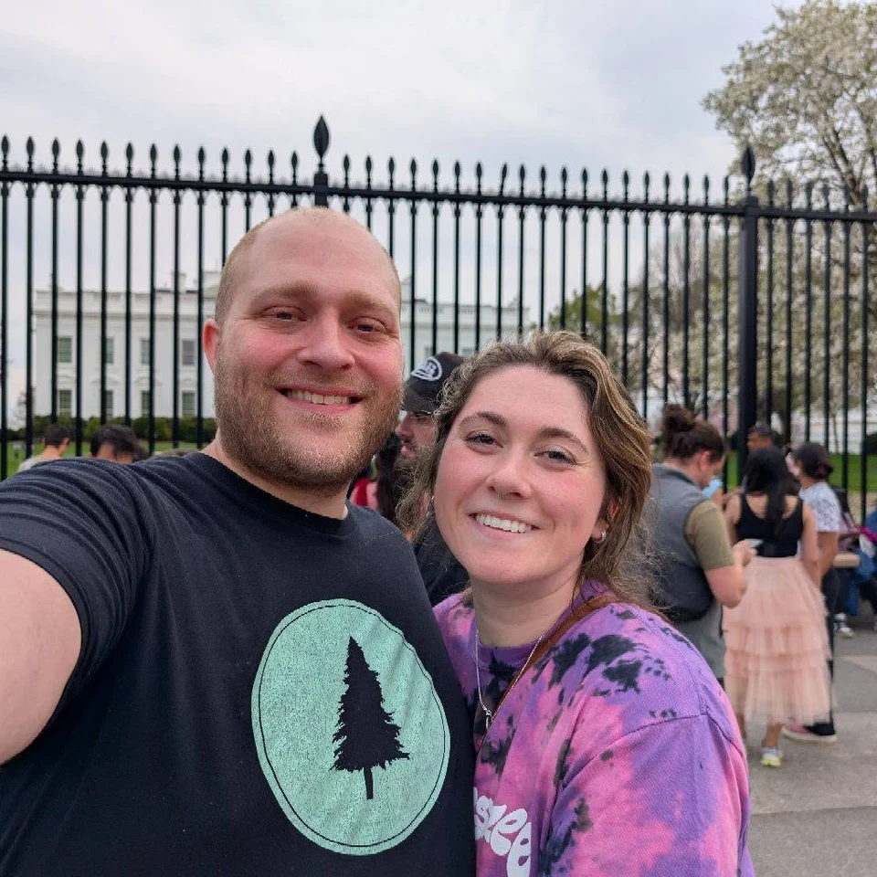 Rebecca Chase and her husband smiling in front of the White House