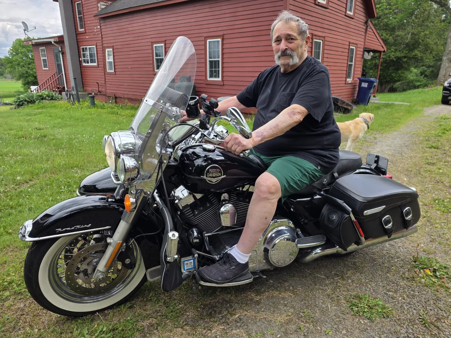 Vic Bronner sitting on his black Harley-Davidson Road King in the driveway at home