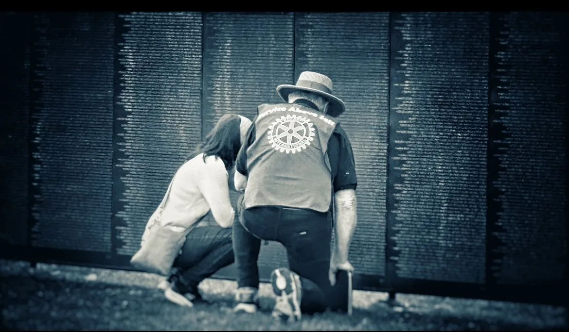 A volunteer assists a visitor at The Wall That Heals